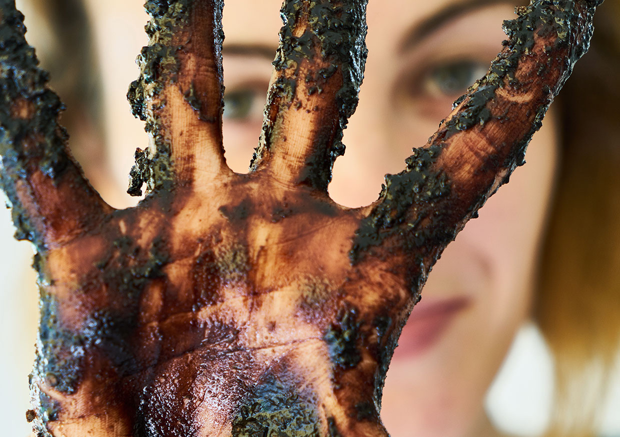 Main chocolatée devant un visage de femme